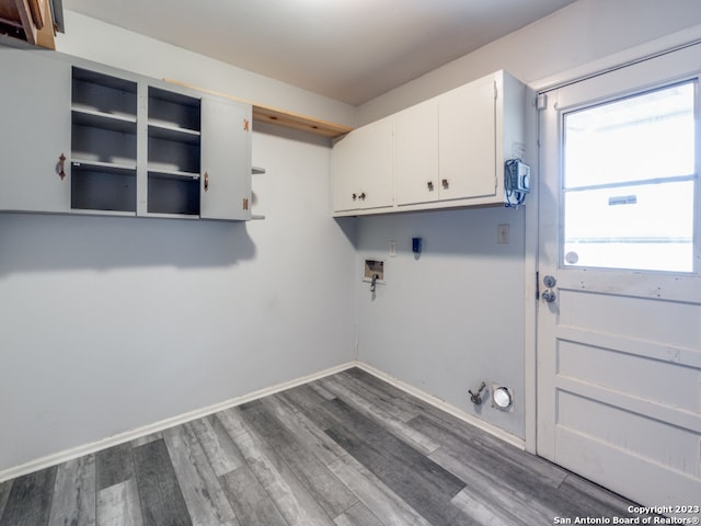 clothes washing area featuring hookup for a washing machine, cabinets, and hardwood / wood-style flooring