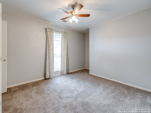 carpeted empty room with ornamental molding, ceiling fan, and a wealth of natural light