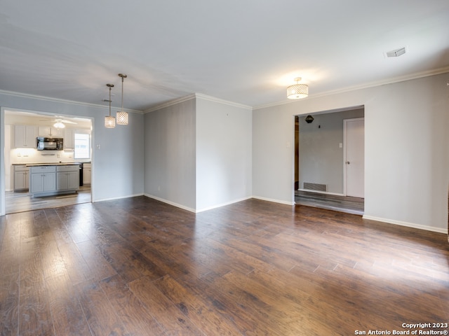 unfurnished living room with ornamental molding, ceiling fan with notable chandelier, and dark hardwood / wood-style flooring