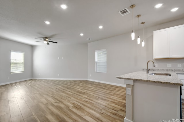 kitchen featuring ceiling fan, light hardwood / wood-style floors, sink, white cabinets, and pendant lighting