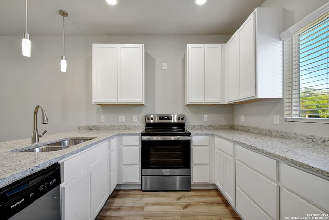 kitchen featuring white cabinets, light wood-type flooring, decorative light fixtures, and appliances with stainless steel finishes