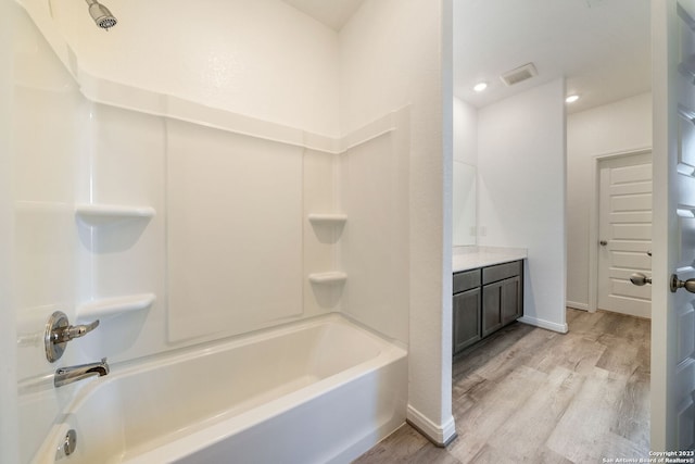 bathroom featuring vanity, hardwood / wood-style flooring, and tub / shower combination