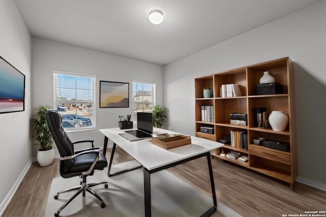 office with a healthy amount of sunlight and hardwood / wood-style floors