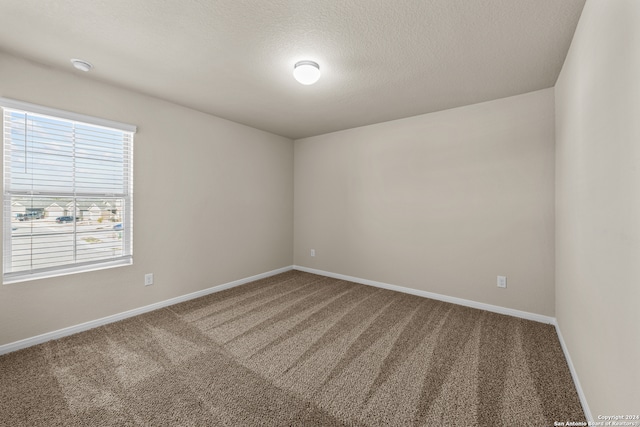 carpeted spare room with a textured ceiling