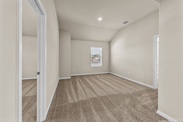 unfurnished room featuring lofted ceiling and carpet