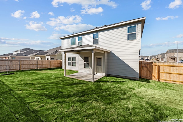 back of property with a patio and a lawn