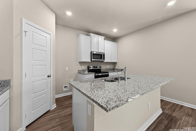 kitchen with sink, white cabinetry, light stone counters, an island with sink, and stainless steel appliances