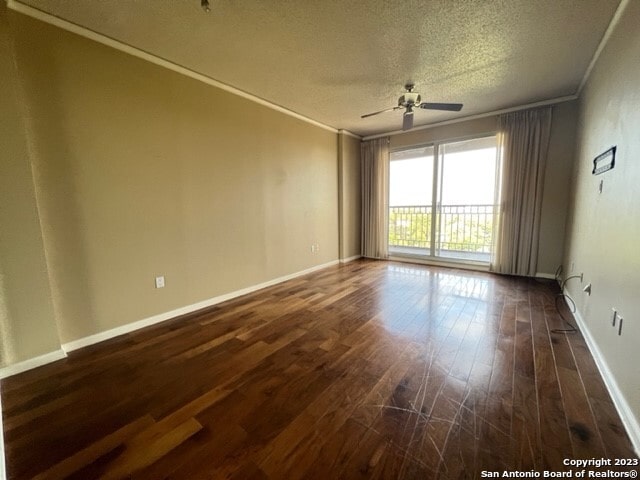 unfurnished room featuring ceiling fan, crown molding, dark hardwood / wood-style floors, and a textured ceiling