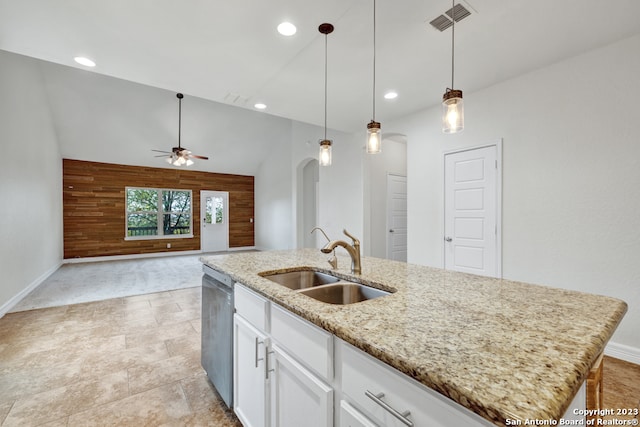 kitchen featuring light stone countertops, white cabinets, hanging light fixtures, a kitchen island with sink, and sink