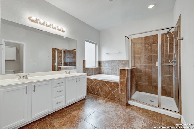 bathroom featuring double sink vanity, shower with separate bathtub, and tile floors