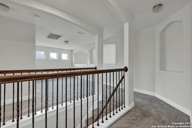 hallway with dark colored carpet