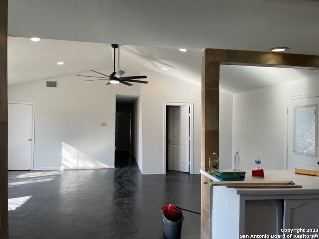 interior space with ceiling fan and vaulted ceiling with beams