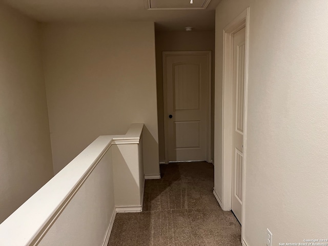 hallway featuring dark colored carpet