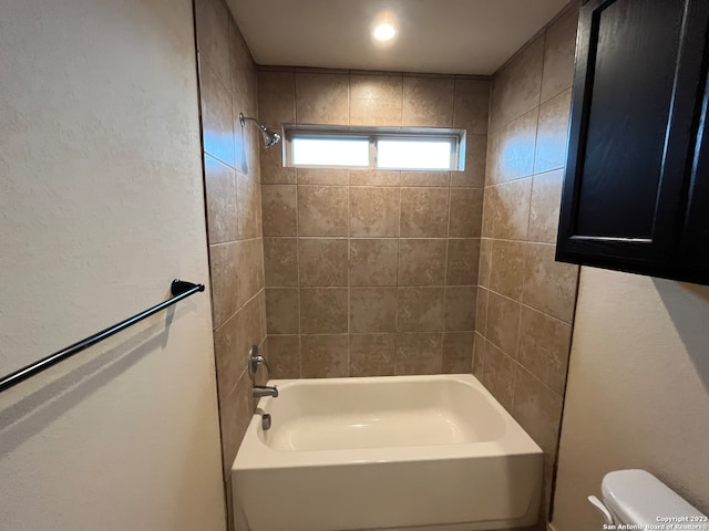 bathroom featuring toilet and tiled shower / bath combo