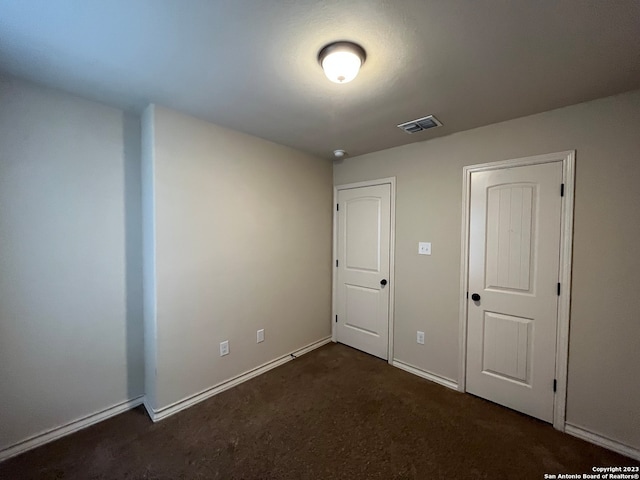 unfurnished bedroom featuring dark carpet