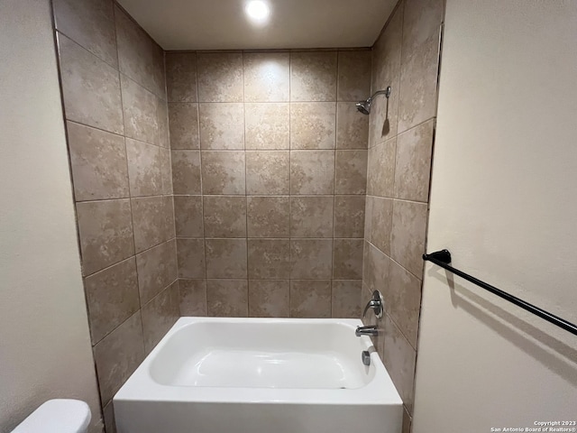 bathroom with tiled shower / bath and toilet