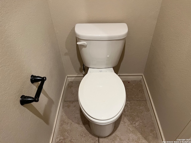 bathroom with toilet and tile flooring