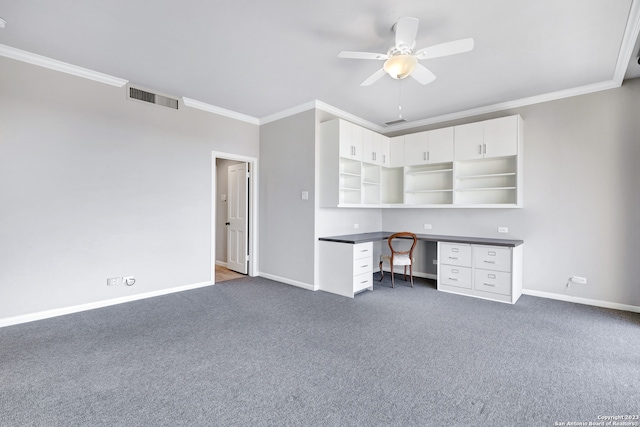 unfurnished office with ceiling fan, crown molding, dark carpet, and built in desk