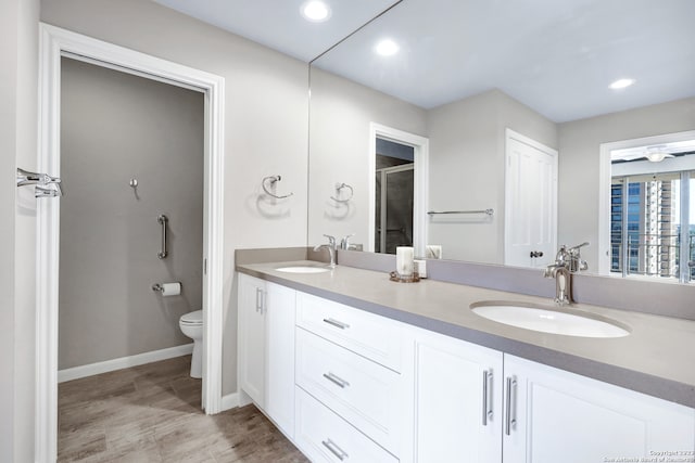 bathroom with ceiling fan, toilet, and dual bowl vanity