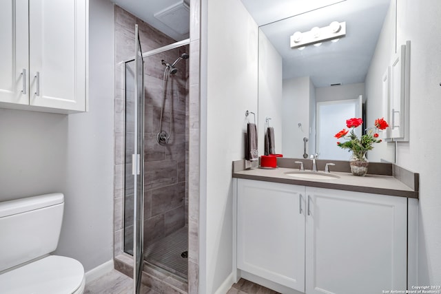 bathroom with walk in shower, toilet, and vanity