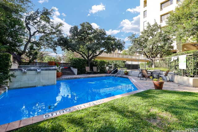 view of swimming pool featuring a patio area and a lawn