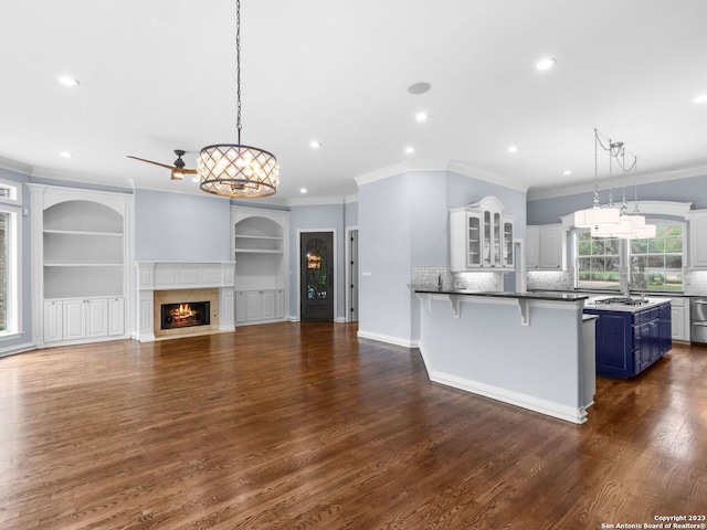 kitchen with decorative light fixtures, dark wood-type flooring, and ornamental molding