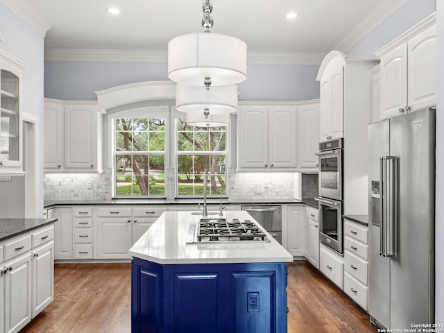 kitchen with tasteful backsplash, a kitchen island, appliances with stainless steel finishes, and white cabinetry