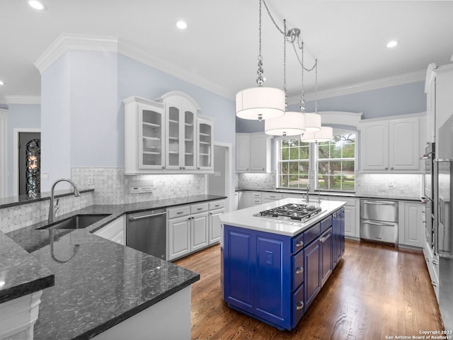 kitchen with blue cabinetry, decorative light fixtures, appliances with stainless steel finishes, and crown molding