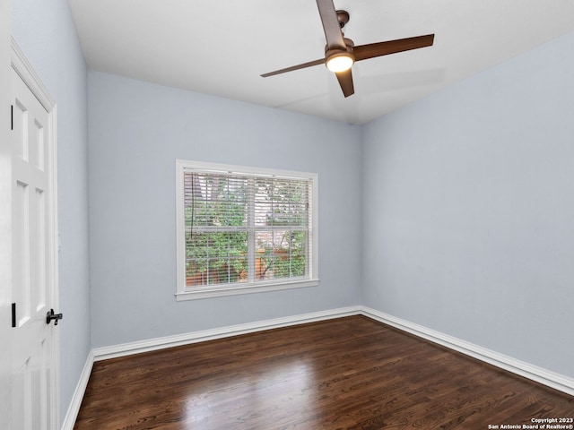 empty room with dark hardwood / wood-style floors and ceiling fan