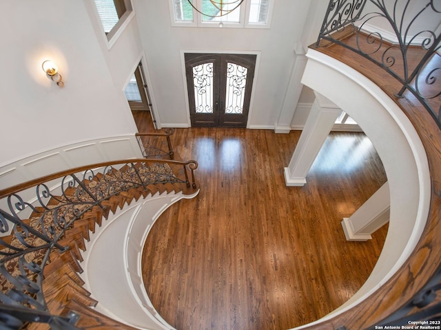 entrance foyer with dark wood-type flooring, a high ceiling, and french doors