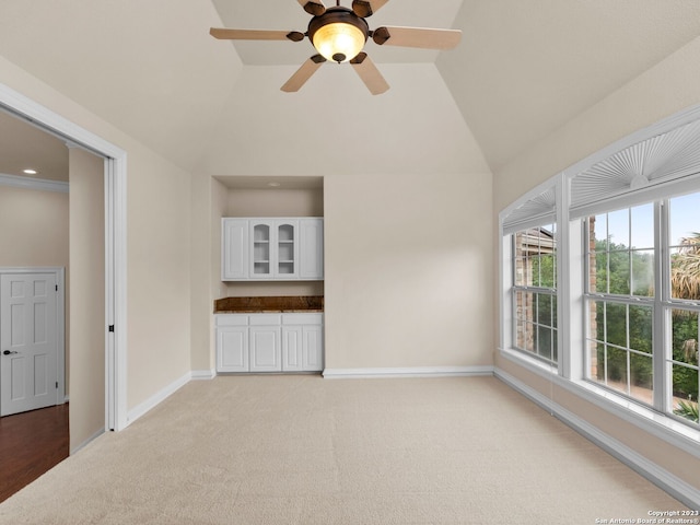 interior space featuring ceiling fan, light carpet, and vaulted ceiling