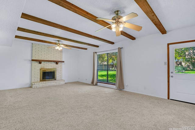 unfurnished living room with beam ceiling, carpet floors, and a brick fireplace