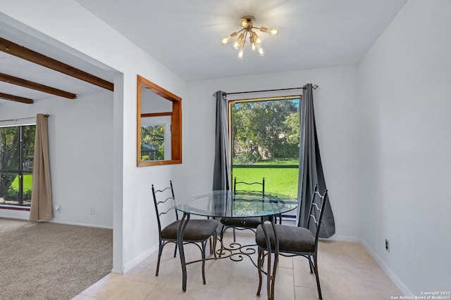 dining room featuring beamed ceiling, light carpet, plenty of natural light, and an inviting chandelier