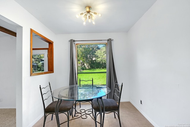 tiled dining room featuring a wealth of natural light and an inviting chandelier