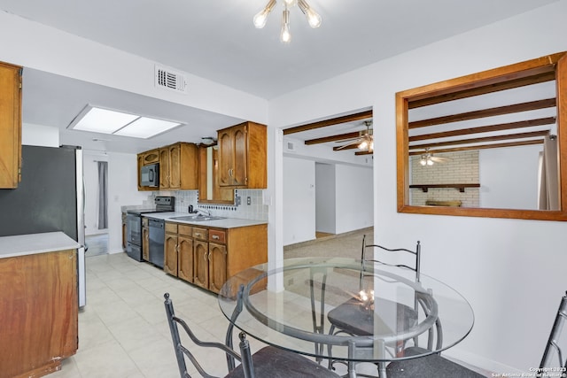 kitchen featuring black appliances, beam ceiling, backsplash, ceiling fan, and light tile floors