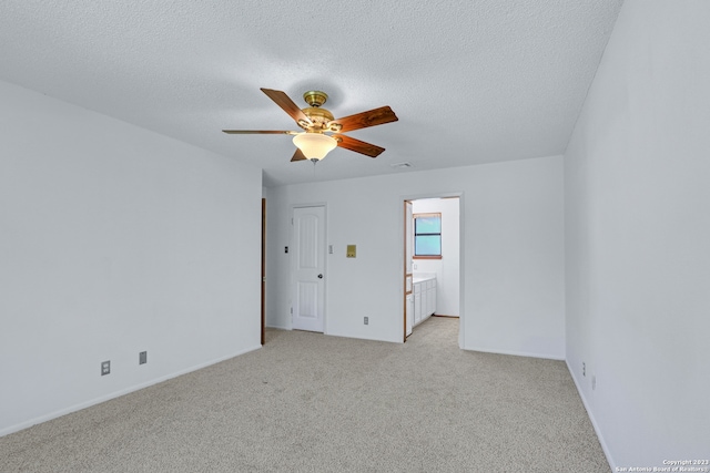 spare room featuring ceiling fan, a textured ceiling, and light carpet