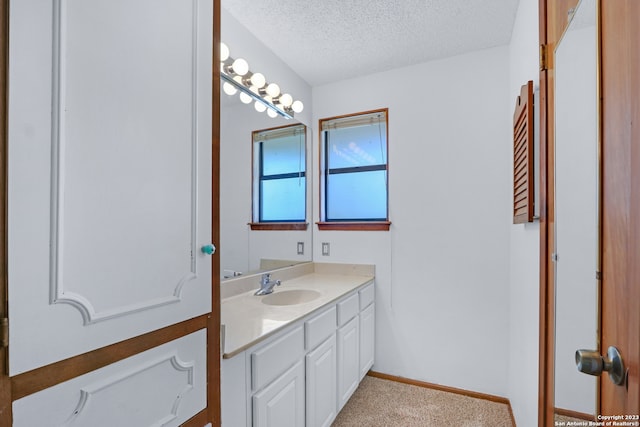 bathroom with vanity with extensive cabinet space and a textured ceiling