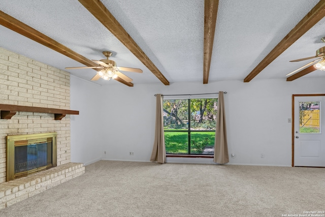 unfurnished living room with carpet, a healthy amount of sunlight, a textured ceiling, and a brick fireplace