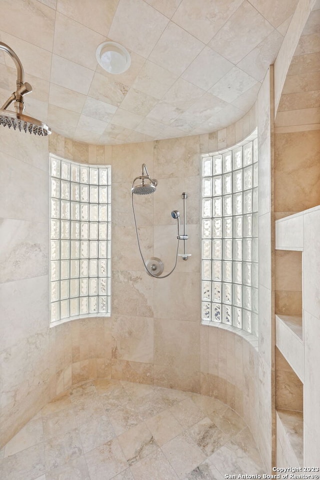 bathroom featuring tiled shower and a wealth of natural light