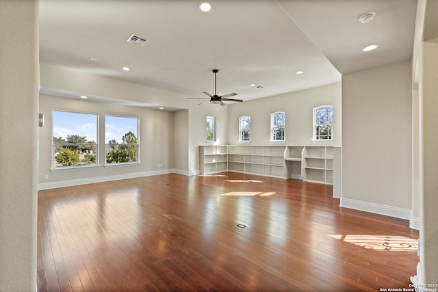 unfurnished living room with dark hardwood / wood-style flooring and ceiling fan