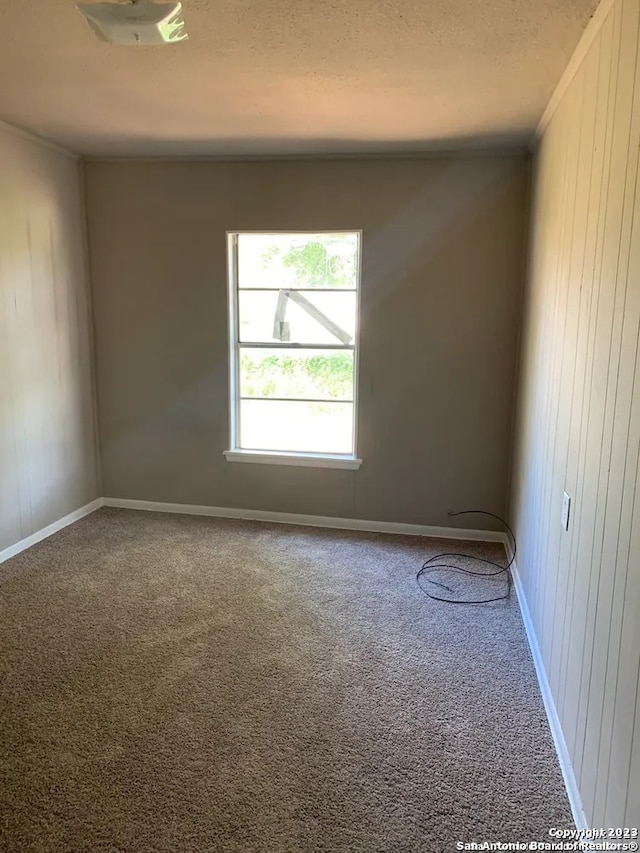 carpeted empty room featuring a textured ceiling