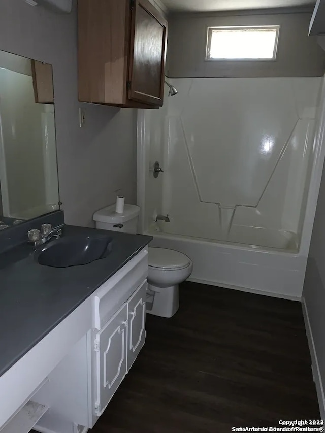 full bathroom with shower / bathtub combination, toilet, hardwood / wood-style floors, and vanity with extensive cabinet space