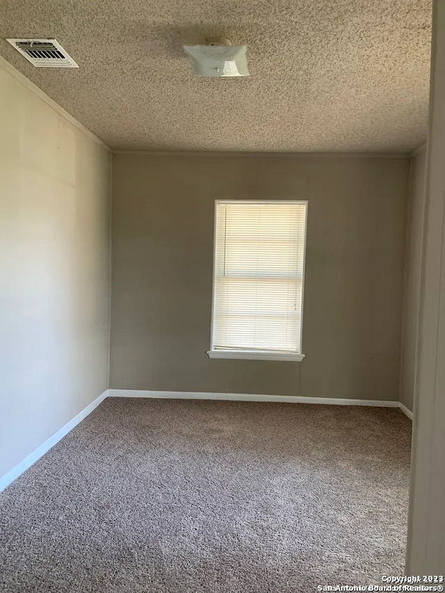 carpeted empty room with a textured ceiling