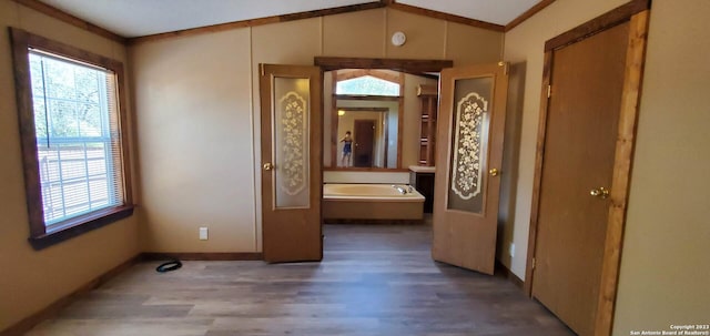 corridor featuring lofted ceiling, crown molding, and dark wood-type flooring