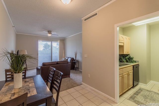 tiled dining room with ceiling fan, a textured ceiling, and crown molding