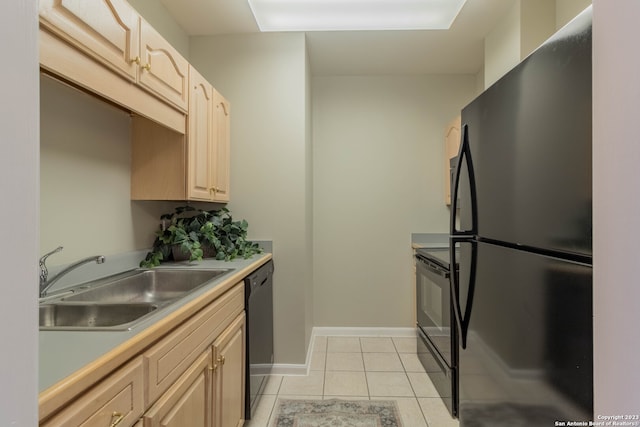 kitchen with light brown cabinets, sink, light tile floors, and black appliances