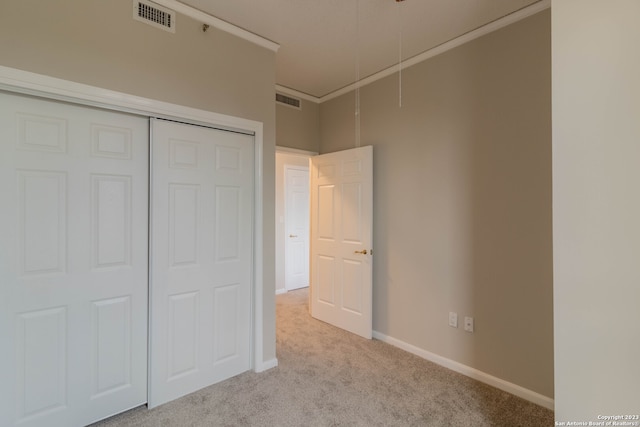 unfurnished bedroom featuring a closet and light carpet