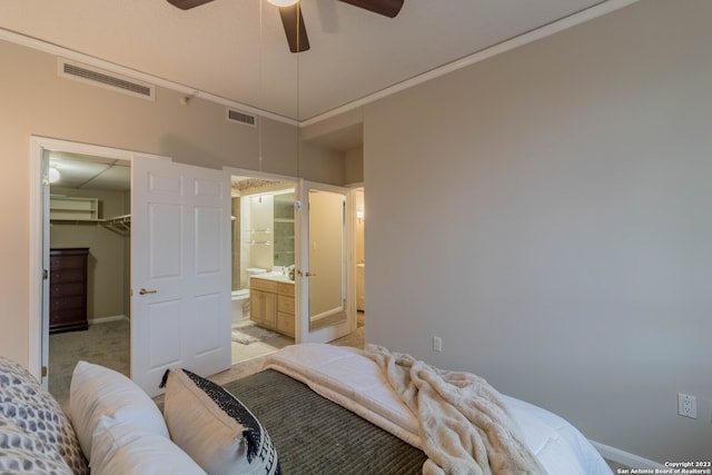 carpeted bedroom with a walk in closet, ensuite bathroom, a closet, and ceiling fan