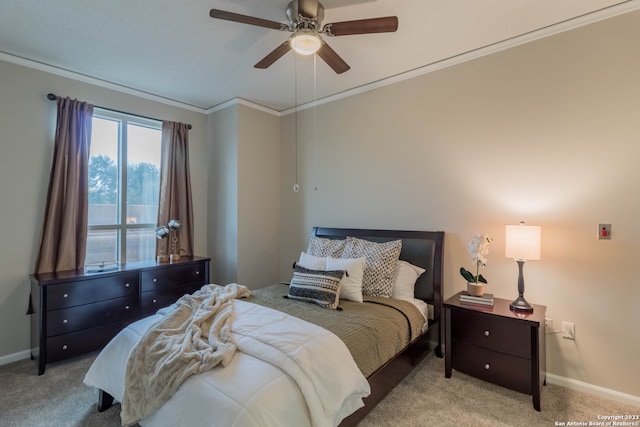 carpeted bedroom featuring ornamental molding and ceiling fan