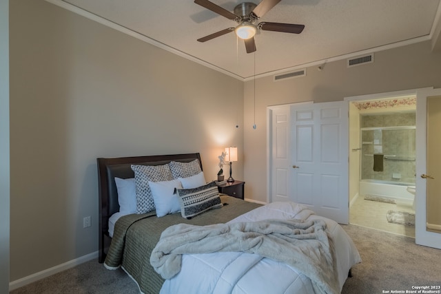 carpeted bedroom with ensuite bath, crown molding, and ceiling fan